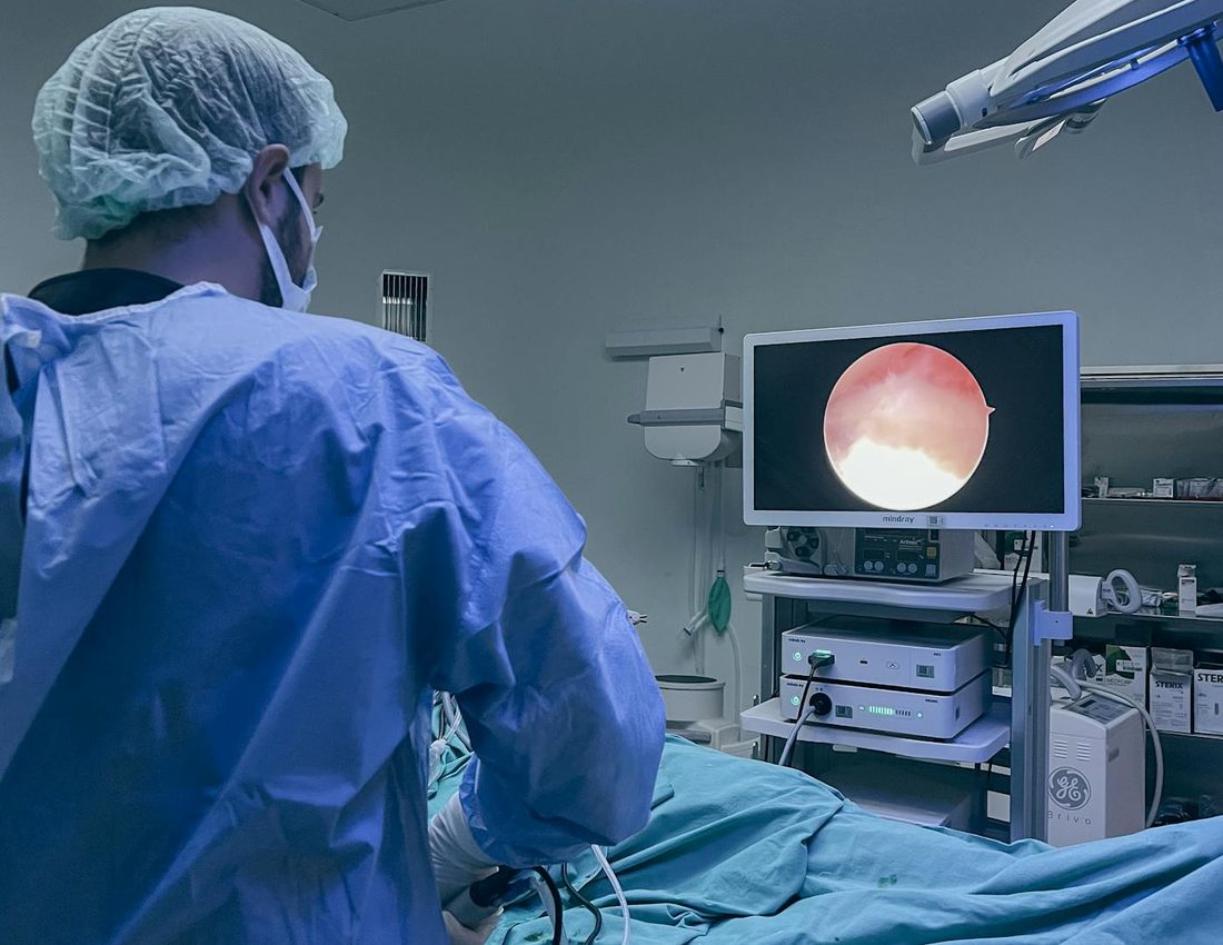 Médico em sala cirúrgica realizando procedimento de retina